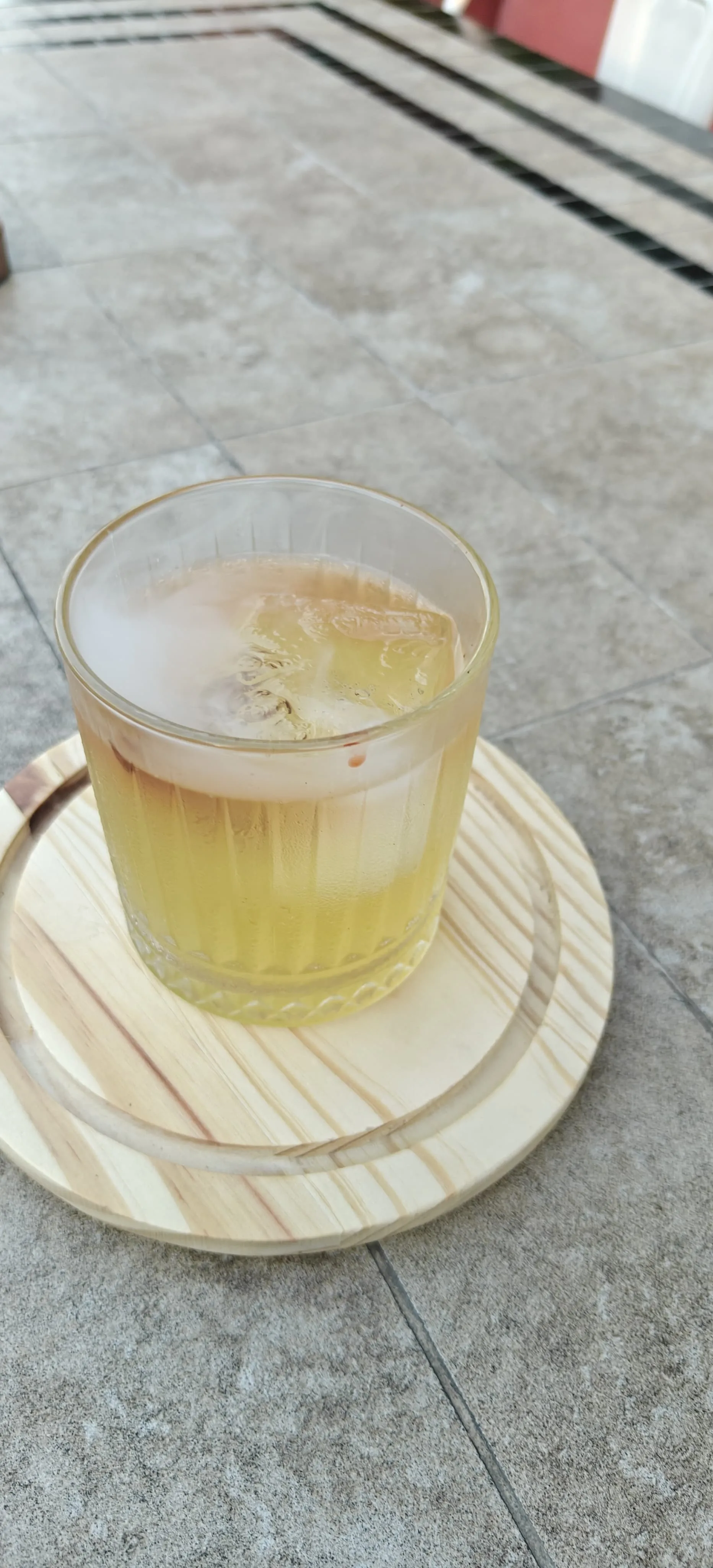 Mama's Smoke Signal — a smoked cocktail finished under a lifted veil of smoke, served on a wooden board